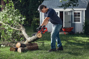 Photo of Craftsman CMCCS610D1 chainsaw cutting a tree branch outdoors, person using tool in backyard.