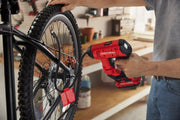 Photo of Craftsman CMCE521B cordless inflator in use inflating a bicycle tire in a workshop.