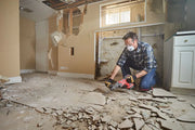 Photo of CRAFTSMAN CMCH234B rotary tool used for floor demolition in a damaged room with broken tiles.