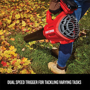 Photo of person using CRAFTSMAN leaf blower CMCK197D1 on autumn leaves outdoors, product viewed from the side.
