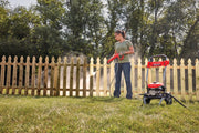 Photo of a person cleaning a wood fence with a Craftsman CMEPW2100 pressure washer outdoors.