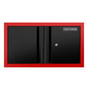 A rectangular wall-mounted storage cabinet with black doors and a red frame, featuring the CRAFTSMAN logo on the top right corner and a key lock on one door.