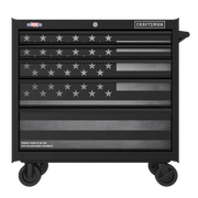 A black rolling tool chest with multiple drawers, featuring a grayscale American flag design across the front. The chest is labeled with 'CRAFTSMAN' branding and has wheels for mobility.