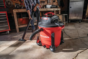 Photo of CRAFTSMAN wet/dry vacuum CMXEVBE17596 in a workshop, red canister, black hose in use on concrete floor.
