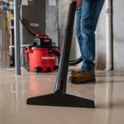Photo of Craftsman wet/dry vacuum CMXZVBE38773 cleaning a wet concrete floor, close-up on nozzle in use.